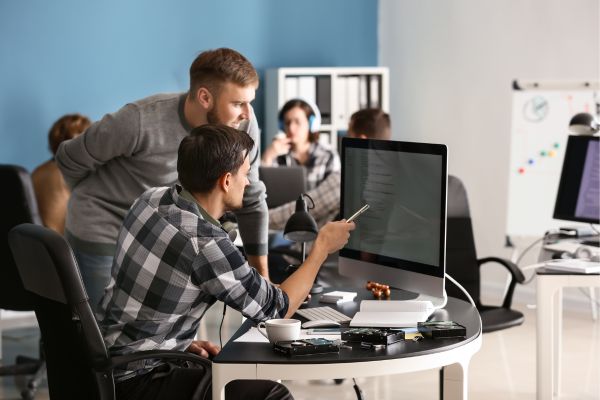 Two coworkers looking at results from a Salesforce health check analysis.